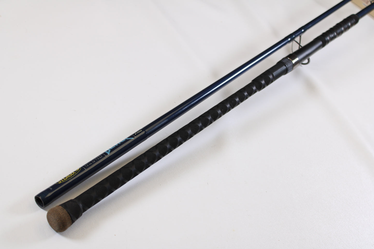 A close-up of two fishing rod handles on a white surface, including a St. Croix Seage SES90MMF2 9'0" Medium 2 Piece Used Spinning Rod—excellent condition, ideal for exchange in the Rod and Reel Trade-In Program to earn store credit.
