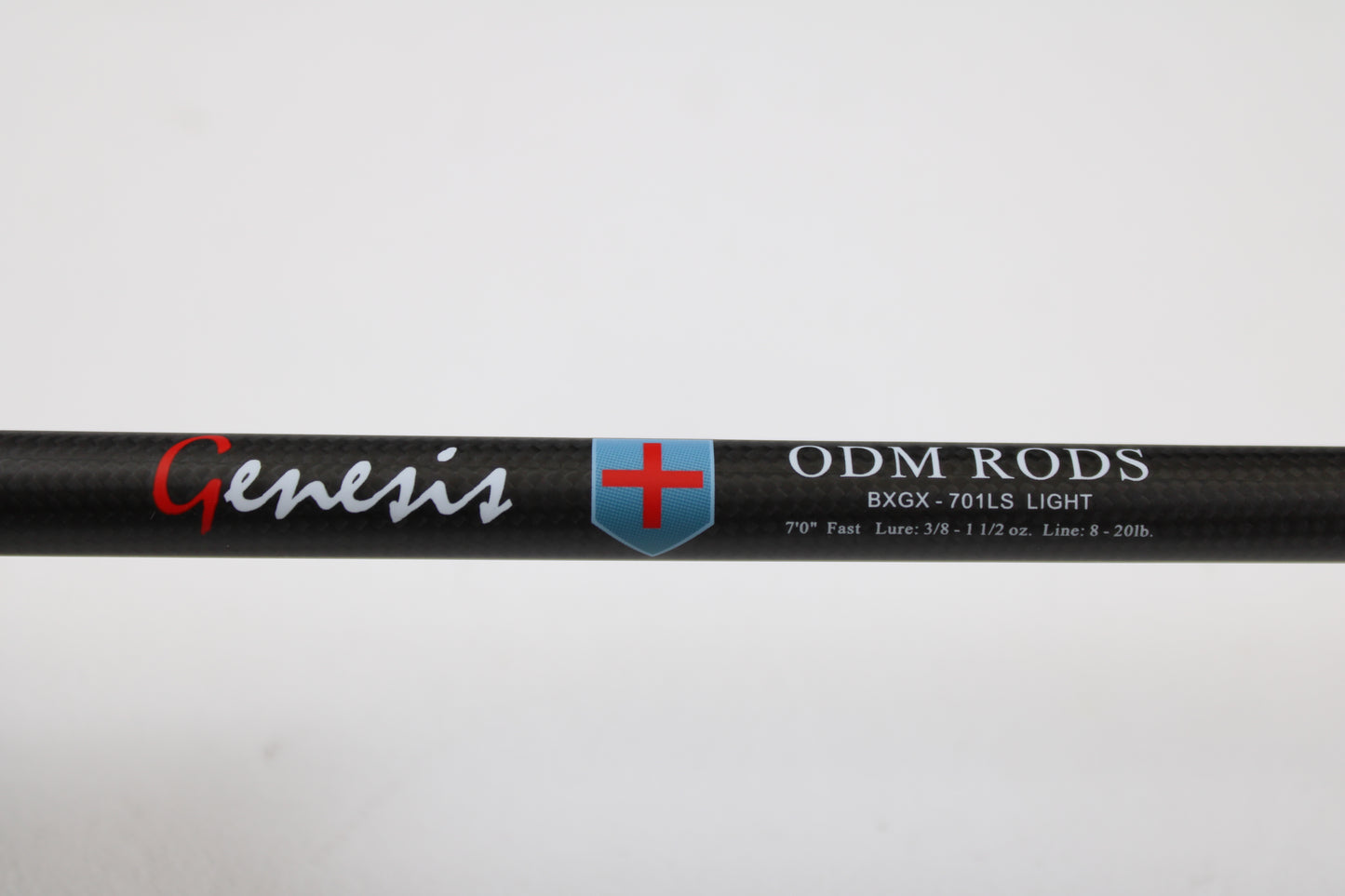 Close-up of a used ODM Rods Genesis Inshore BXGX-701LS 7'0" Light spinning rod in excellent condition, with specs printed on black carbon fiber—great for those interested in quality used gear or trading in a rod and reel.