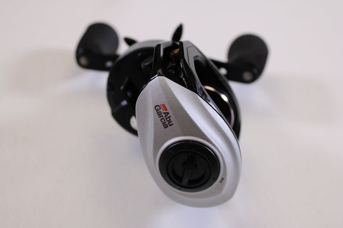 A close-up of an Abu Garcia Revo STX Gen 4 REVO3STX-HS 7.3:1 RH used casting reel in excellent condition, displaying the brand logo and adjustment dial—ideal for those upgrading with our rod and reel trade-in program.