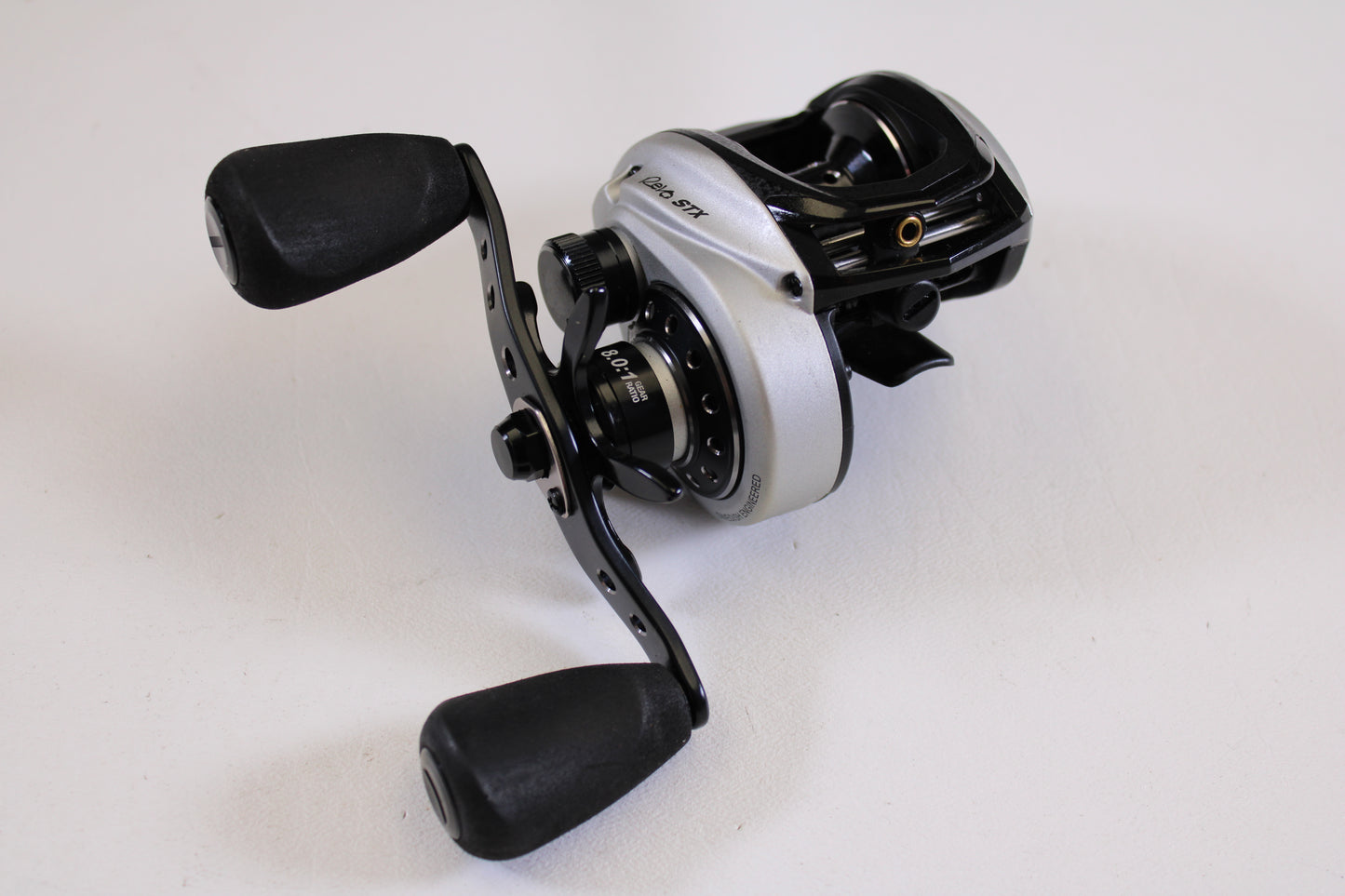 A close-up of the Abu Garcia Revo STX Gen 4 REVO3STX-SHS 8.0:1 RH, a used casting reel in excellent condition—ideal for those looking to upgrade through our Rod and Reel Trade-In Program.