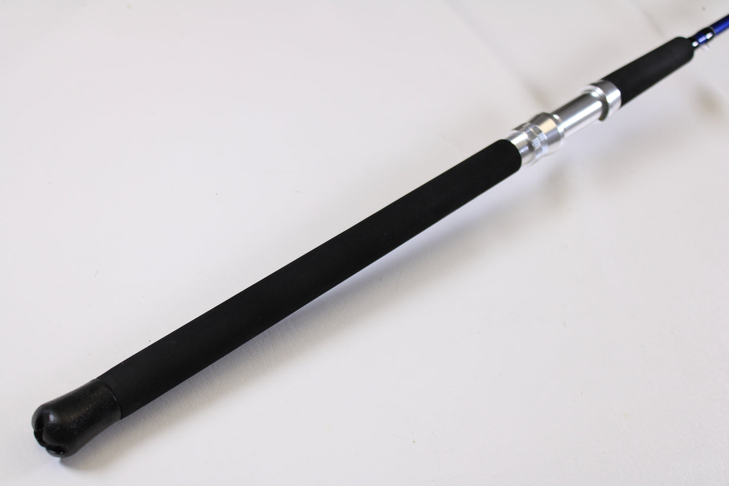 A close-up of the Shattered Cat 7'6" Heavy Casting Rod handle with a black foam grip and metallic reel seat—ideal for anglers looking to trade in or use store credit on this used Shattered Cat rod in excellent condition.