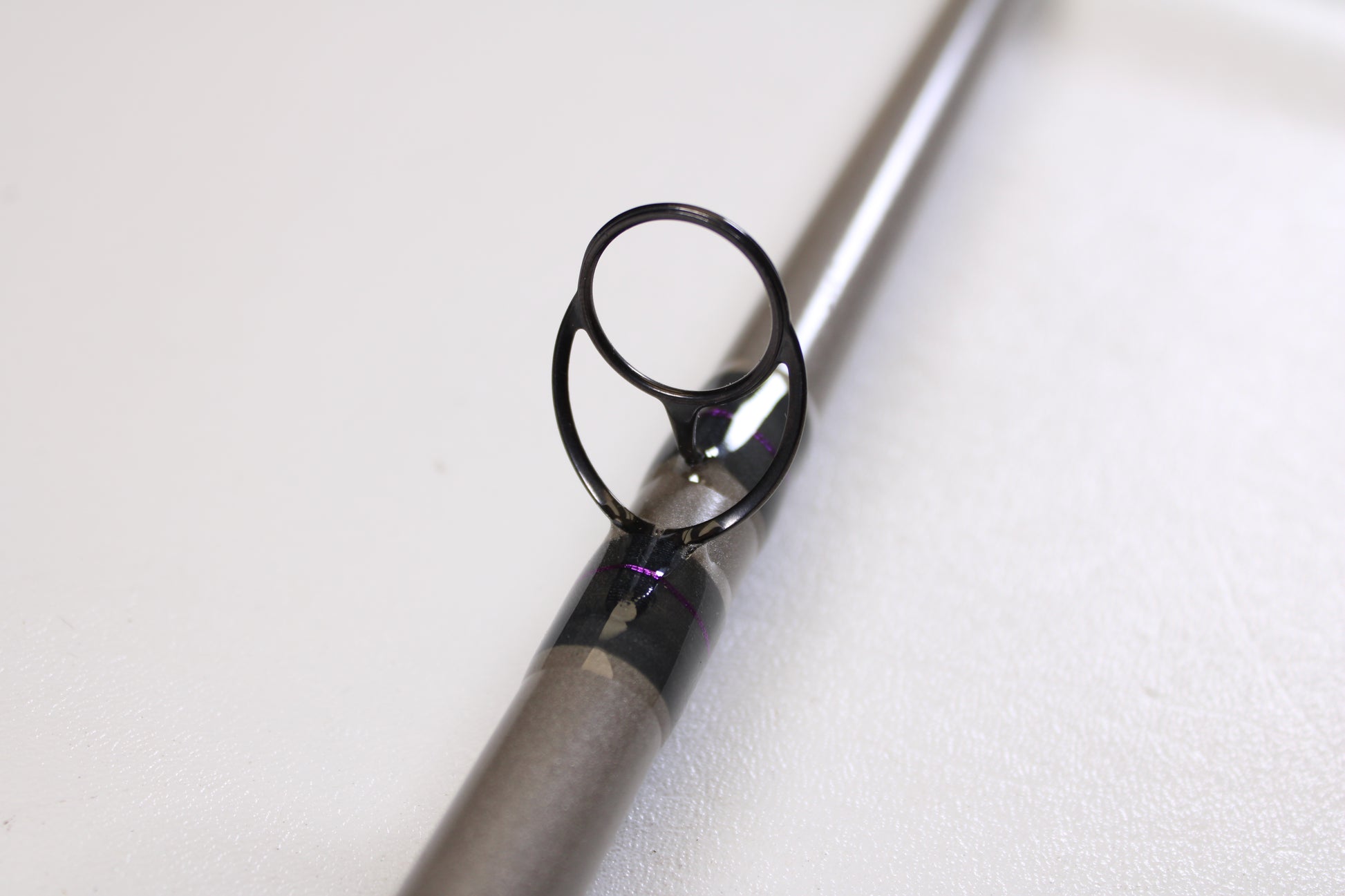 Close-up of the St. Croix Mojo Musky Trolling MMT80HM 8'0" Heavy—Used Casting Rod in mint condition, focusing on the metal guide and support. Great for those upgrading gear with our Rod and Reel Trade-In Program for store credit.