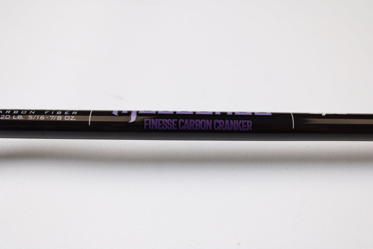 A close-up of the St. Croix Mojo Bass JOC72MHMF Finesse Carbon Cranker 7'2" Medium Heavy Used Casting Rod in excellent condition, with "FINESSE CARBON CRANKER" in purple—ideal for upgrading via our Rod and Reel Trade-In Program.