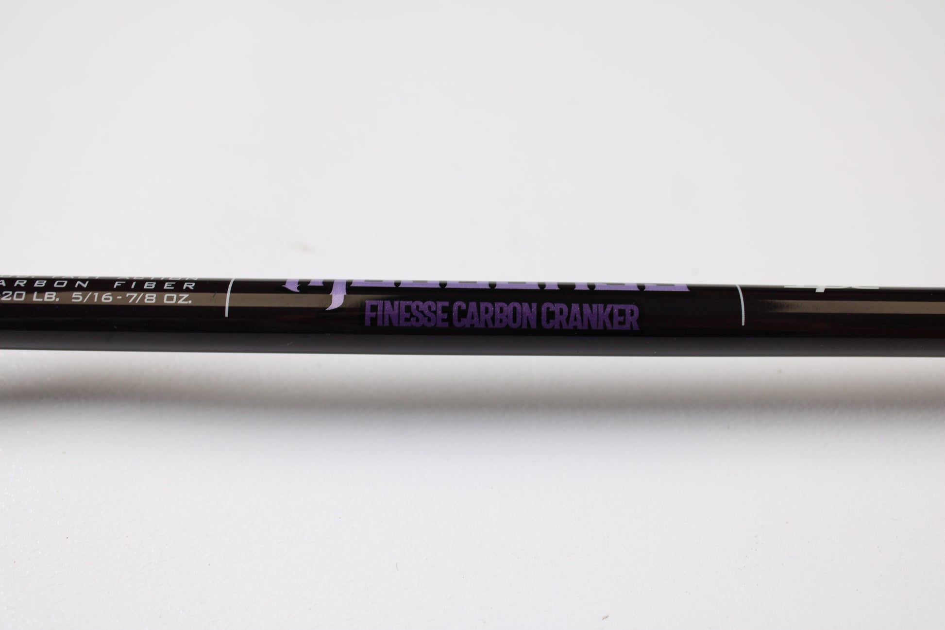 A close-up of the St. Croix Mojo Bass JOC72MHMF Finesse Carbon Cranker 7'2" Medium Heavy Used Casting Rod in excellent condition, with "FINESSE CARBON CRANKER" in purple—ideal for upgrading via our Rod and Reel Trade-In Program.
