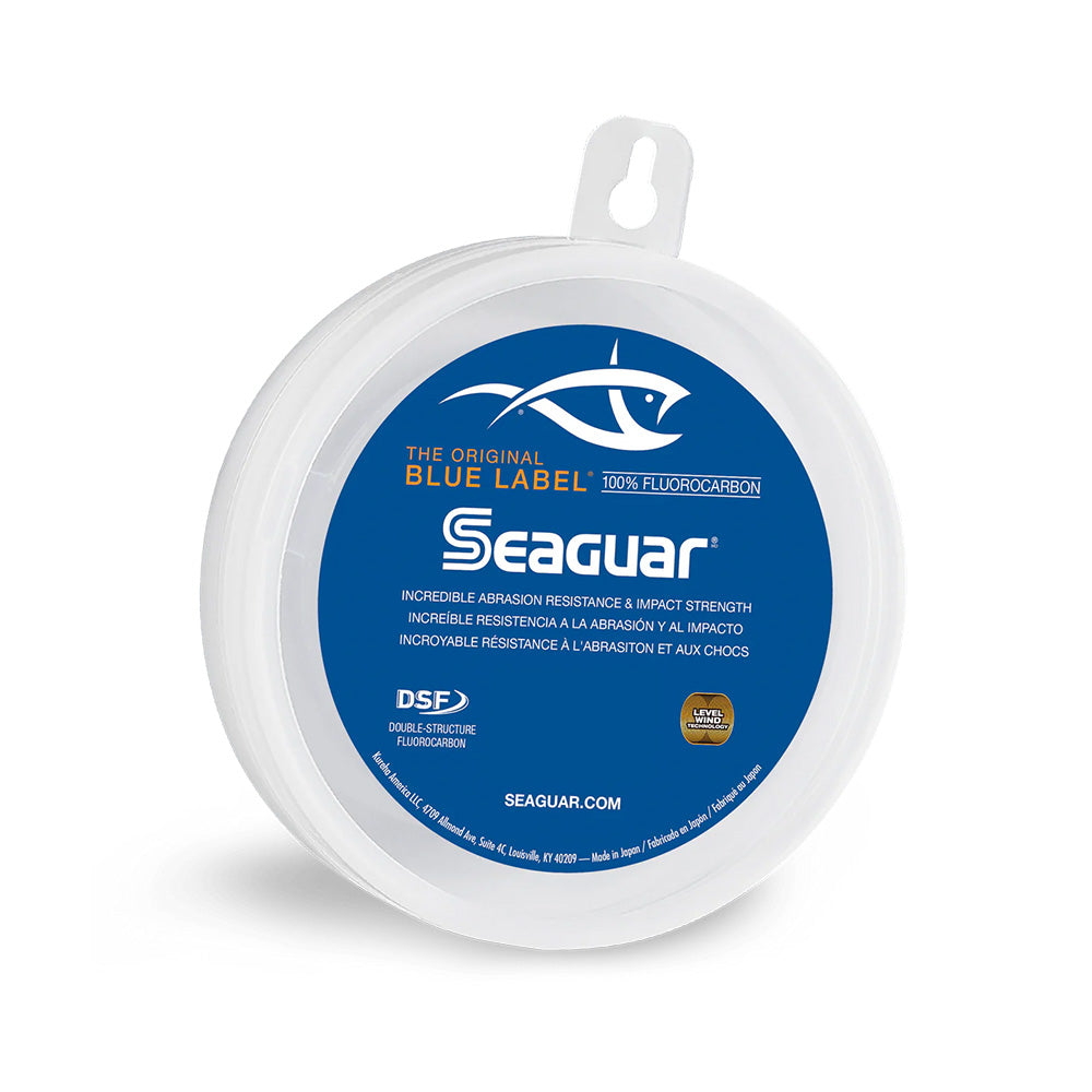 A spool of Seaguar Blue Label Fluorocarbon Leader by Seaguar, featuring superior knot strength and a blue and white label with a fish graphic and product details in English, Spanish, and French.