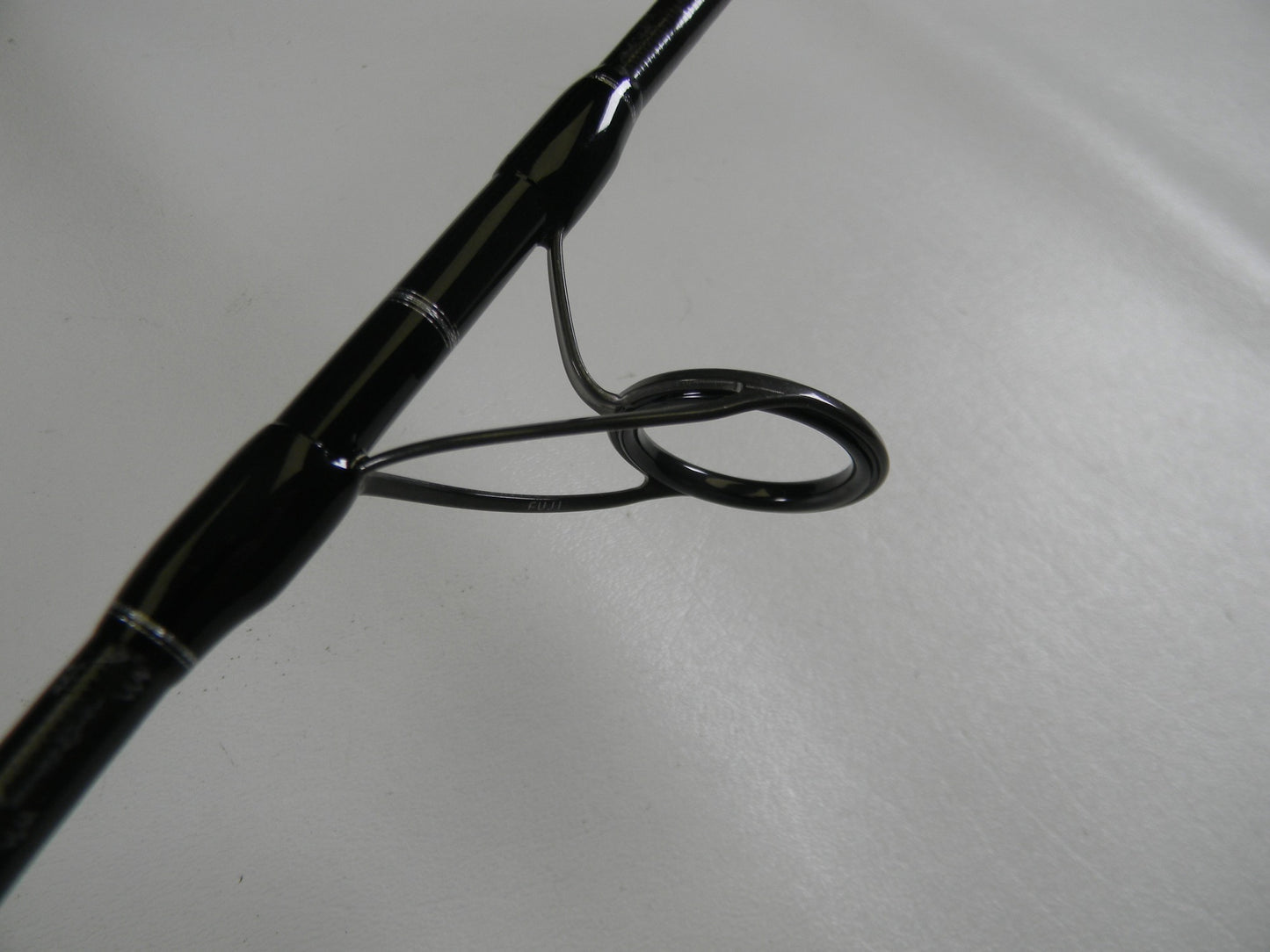 A close-up of a Shimano Grappler Type C GRPCS70L 7'0" Light Used Spinning Rod guide, showing the ring and frame—ideal for those exploring used Shimano rods or our Rod and Reel Trade-In Program for store credit.