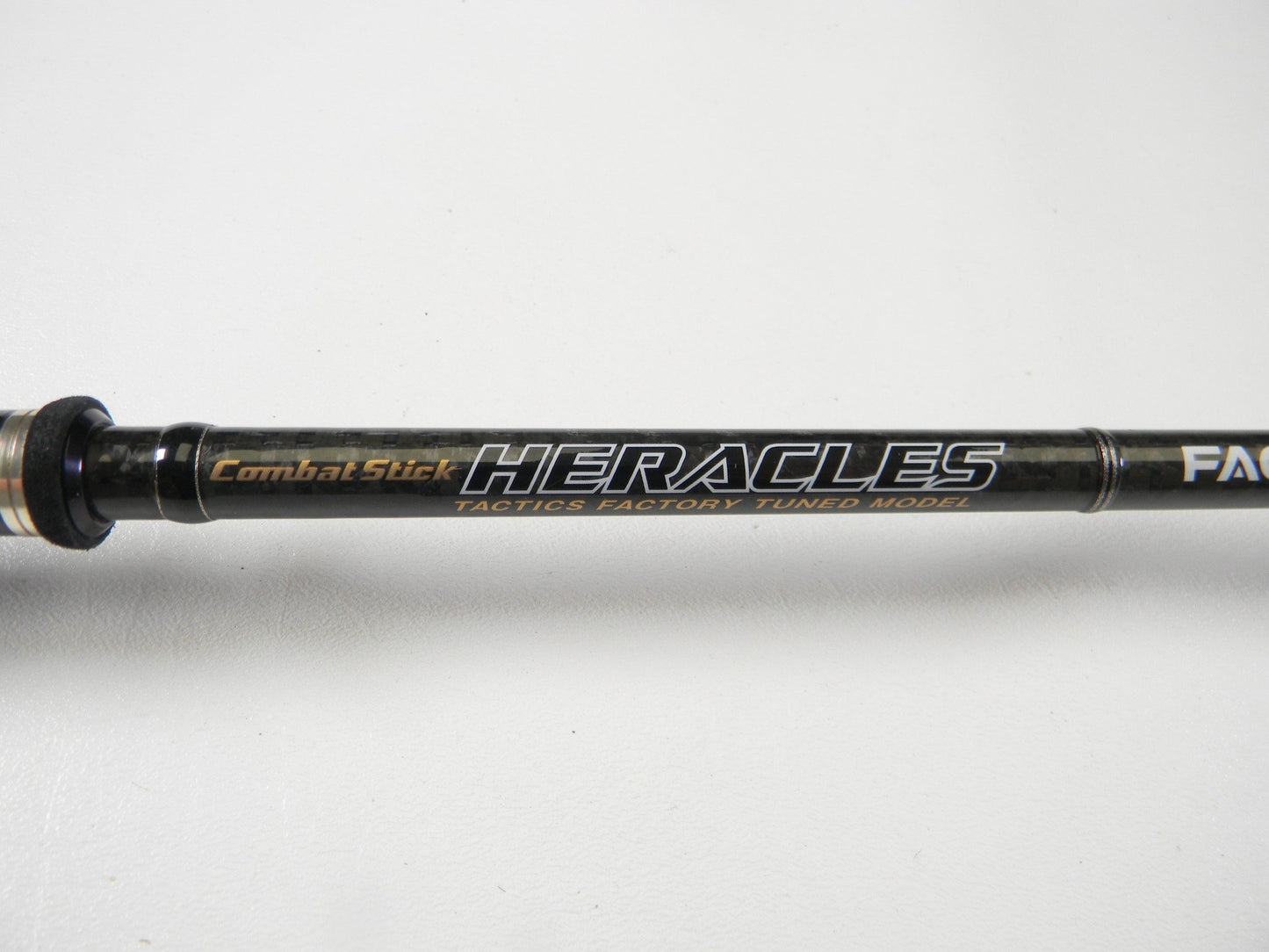 Close-up of the Evergreen Combat Stick Heracles HFAC-70HST Fact 7'0" Heavy Used Casting Rod in excellent condition, black shaft branded with "Combat Stick HERACLES"—ideal for our Rod and Reel Trade-In Program for store credit or used gear.