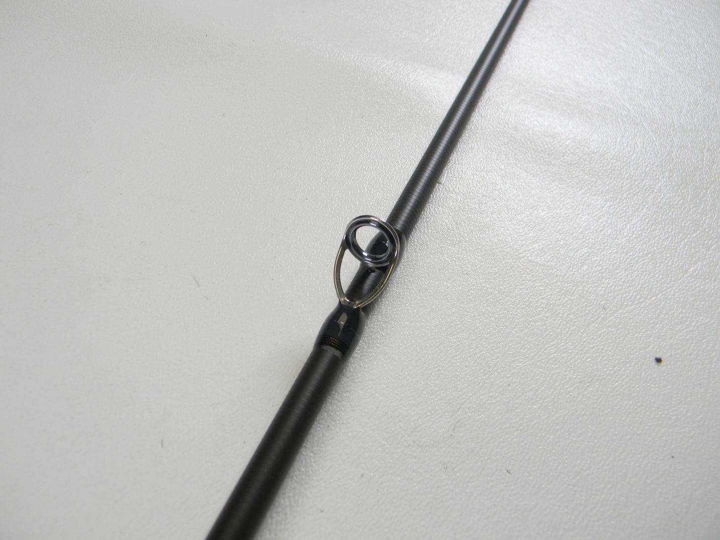 Close-up of a Megabass Destroyer P5 F4-65X OneTen Stick 6'5" Medium Used Casting Rod in excellent condition, highlighting its metal line guide—ideal for upgrading your gear or trading in with our store credit program.