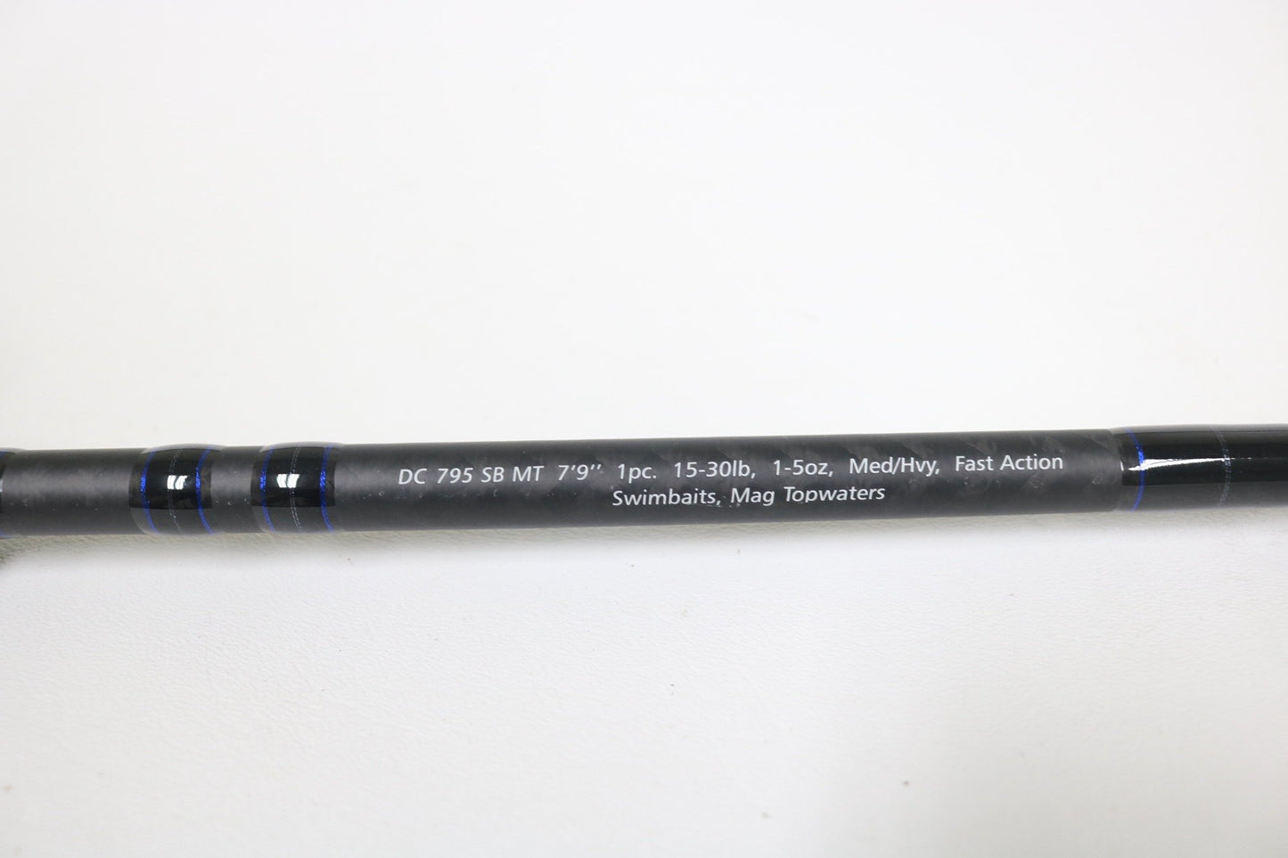 A close-up of the Dobyns Champion XP DC 795SB MT 7'9" Medium Heavy Used Casting Rod in excellent condition, shown on a black background with blue accents—ideal for our rod and reel trade-in program.