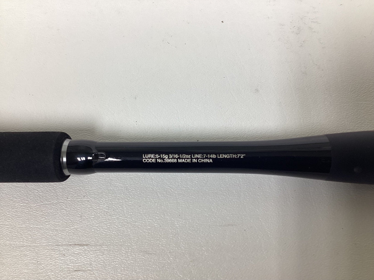 A close-up of a Shimano Zodias ZDC72MLBFSA Used Casting Rod in excellent condition, showing white specs like lure weight, line weight, and 7'2" length on the black rod with "Made in China," set against a plain white background.