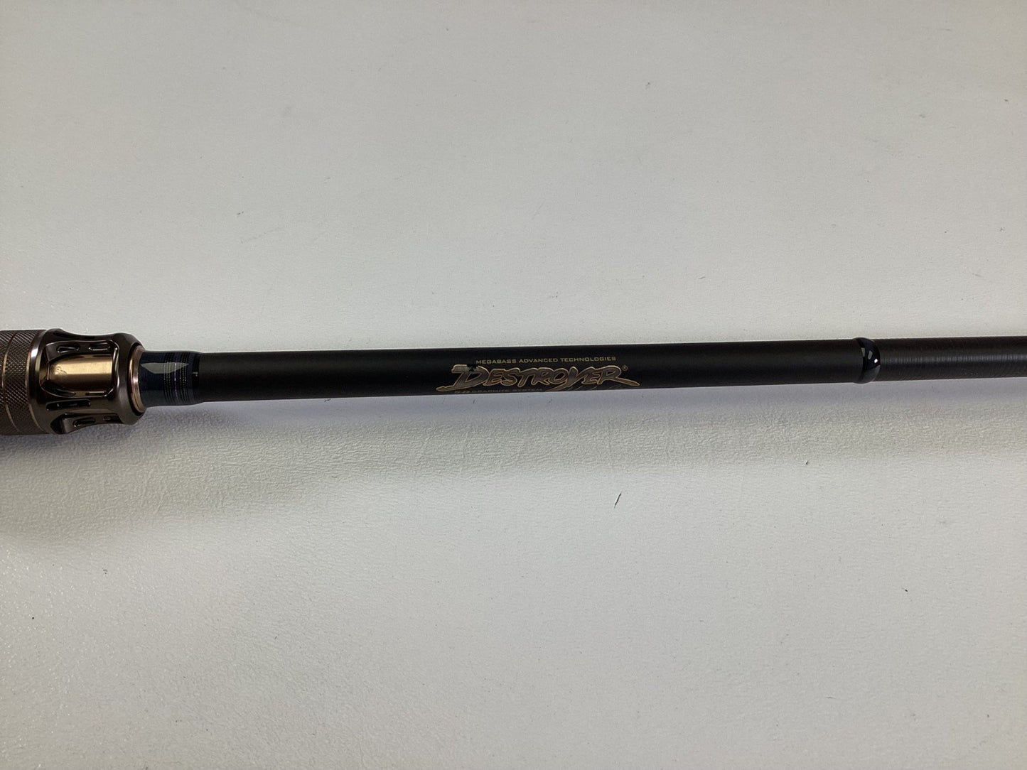 A close-up of the Megabass Destroyer P5 F3.1/2-70X Used Casting Rod in excellent condition, featuring a black shaft with metallic accents and "Destroyer" in gold lettering, set against a light background.