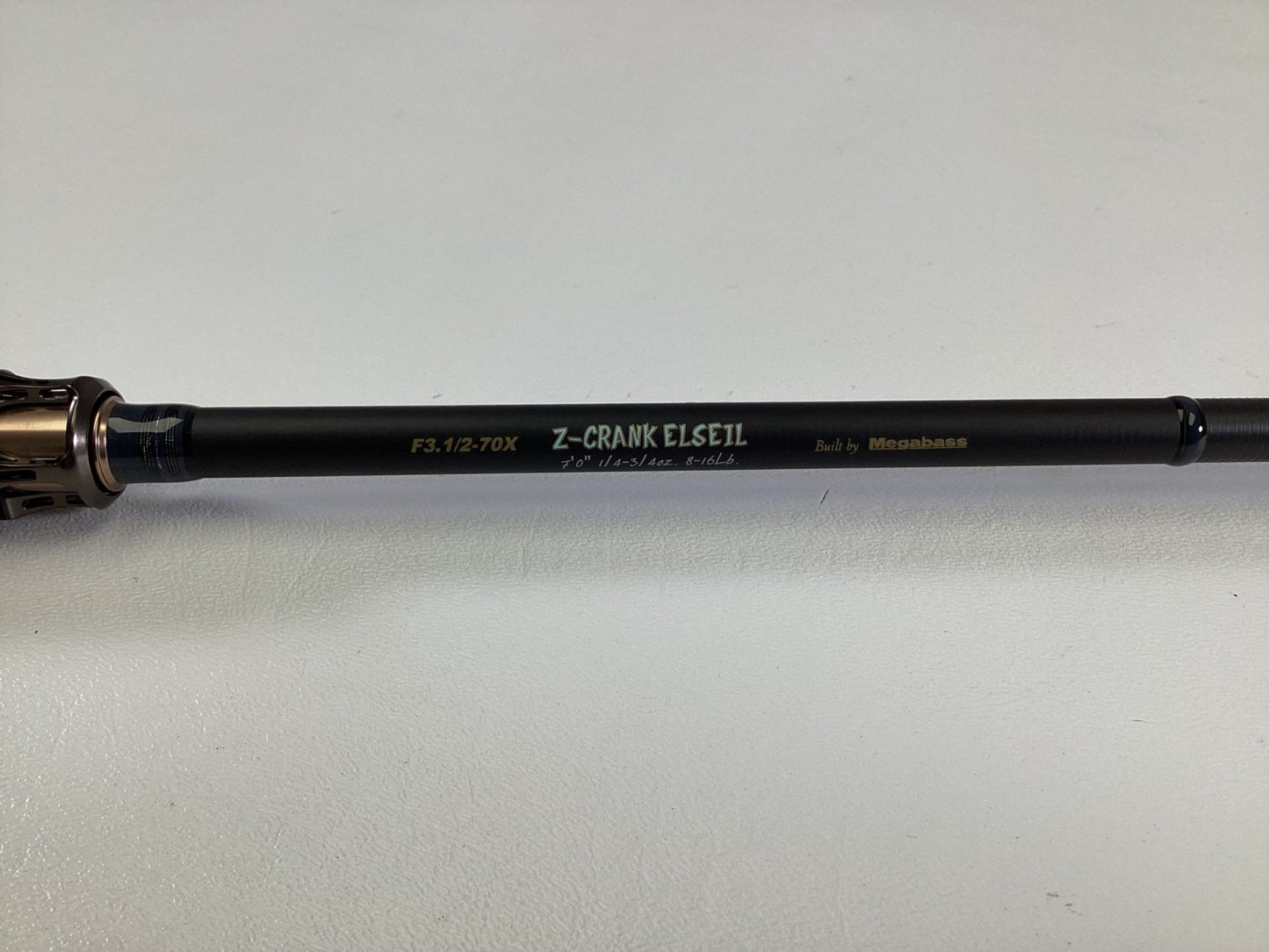 A close-up of a Megabass Destroyer P5 F3.1/2-70X Used Casting Rod in excellent condition, featuring “Exclusively Built” and “Built by Megabass” labels on a light surface.