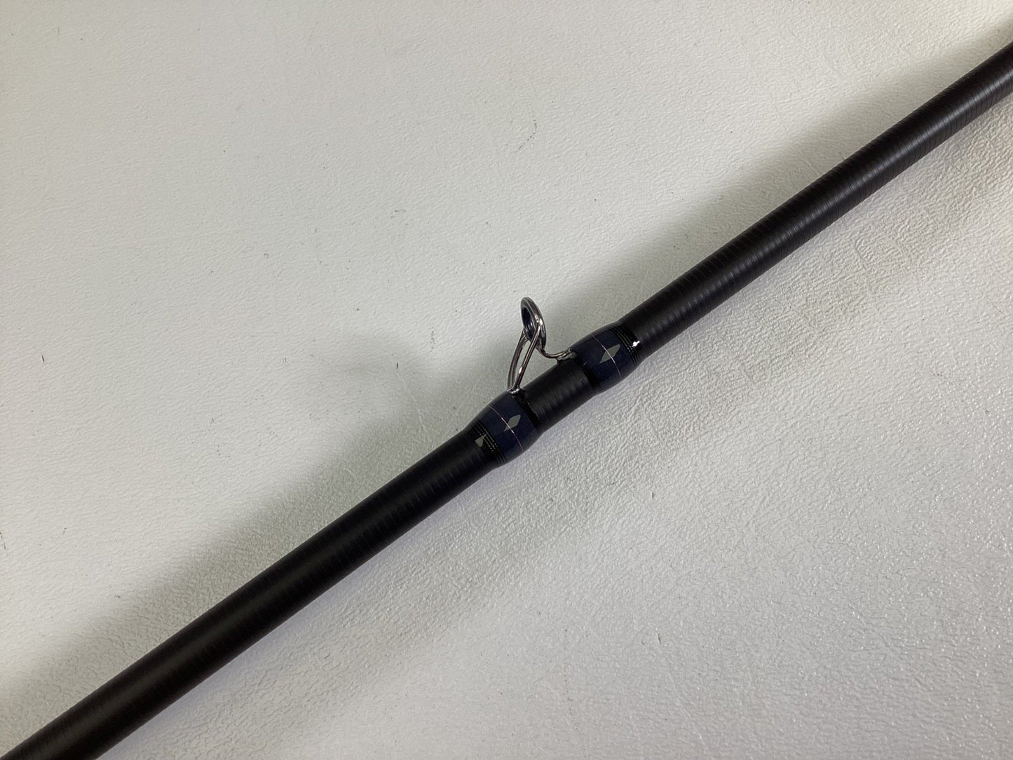 A close-up of the Megabass Destroyer P5 F3.1/2-70X Used Casting Rod in excellent condition, highlighting one of its line guides against a plain white background.