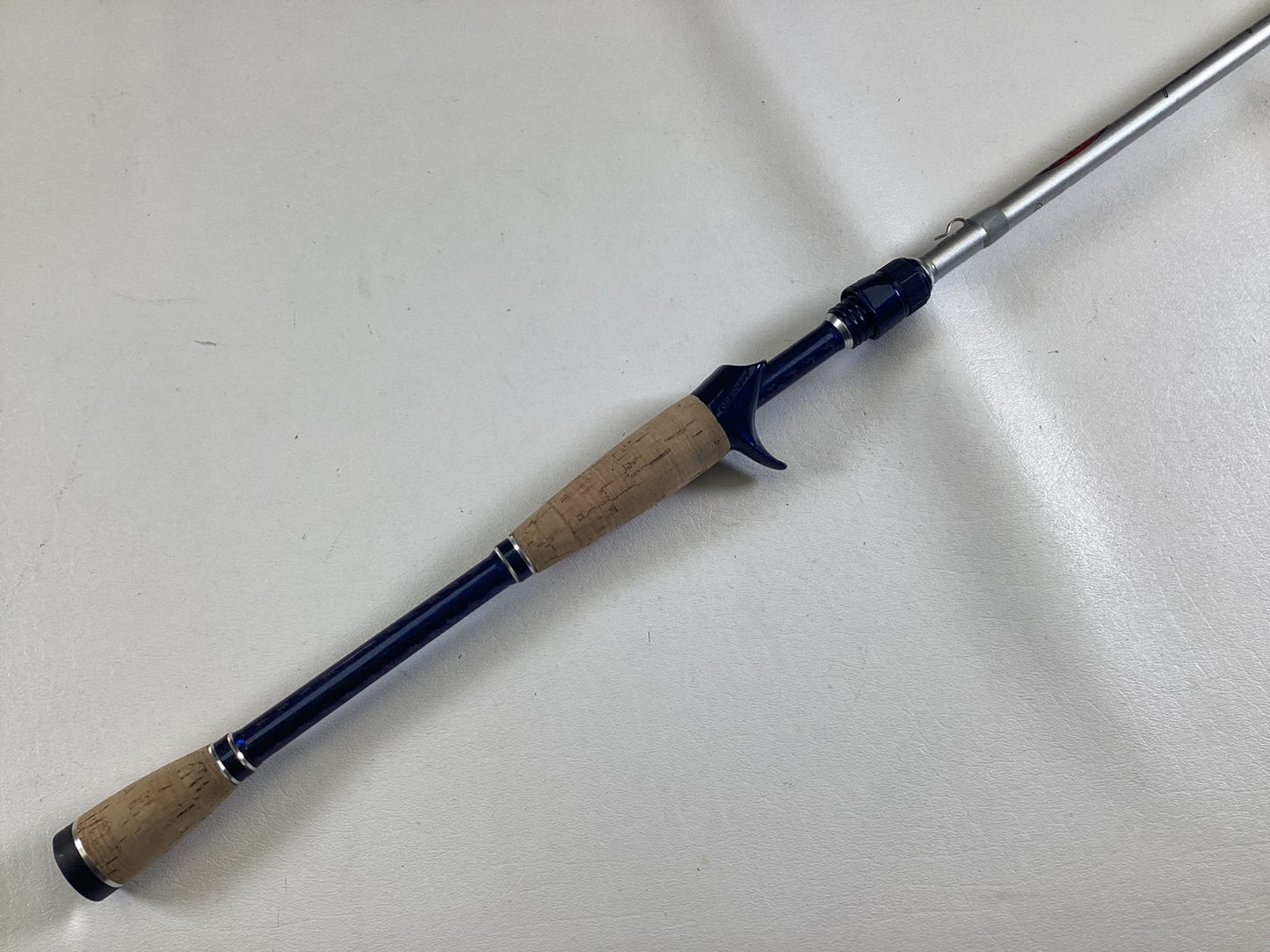 The Duckett Jacob Wheeler Select DFWS73M-CC 7'3" Medium Crankin - Used Casting Rod, in excellent condition, features a cork handle and dark blue accents—ideal for our Used Gear or Rod and Reel Trade-In Program.