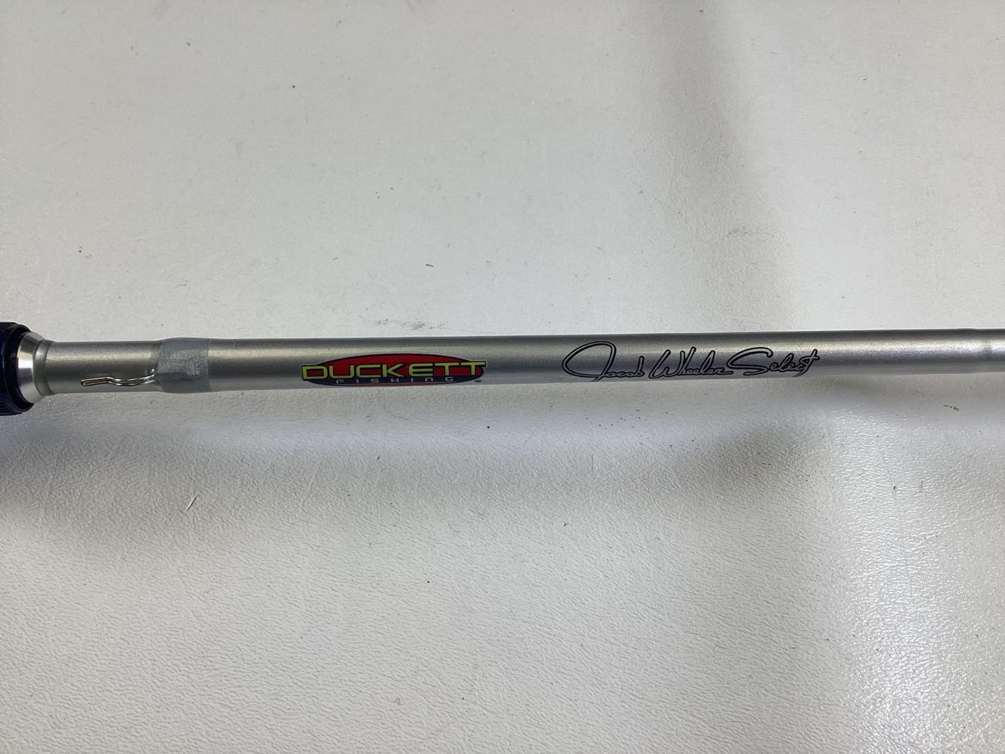 A close-up of the Duckett Jacob Wheeler Select DFWS73M-CC 7'3" Medium Crankin Used Casting Rod in excellent condition, featuring the "DUCKETT" logo and "Jacob Wheeler Series." Trade in your used gear for store credit today!.