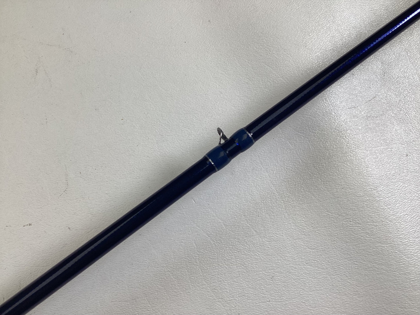 A close-up of a Duckett Jacob Wheeler Select DFWS73M-CC 7'3" Medium Crankin used casting rod in excellent condition with a metal guide ring, ideal for those interested in our Rod and Reel Trade-In Program.