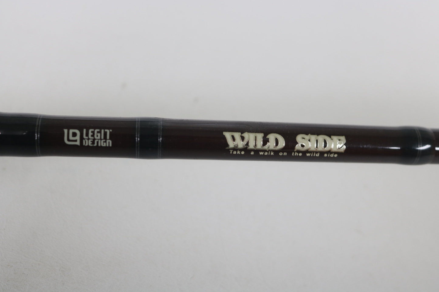 A close-up of the Legit Design Wild Side WSC-G66ML 6'6" Medium Light Used Casting Rod in good condition, showing "LEGIT DESIGN" and "WILD SIDE Take a walk on the wild side" text—ideal for quality gear seekers or trade-ins.