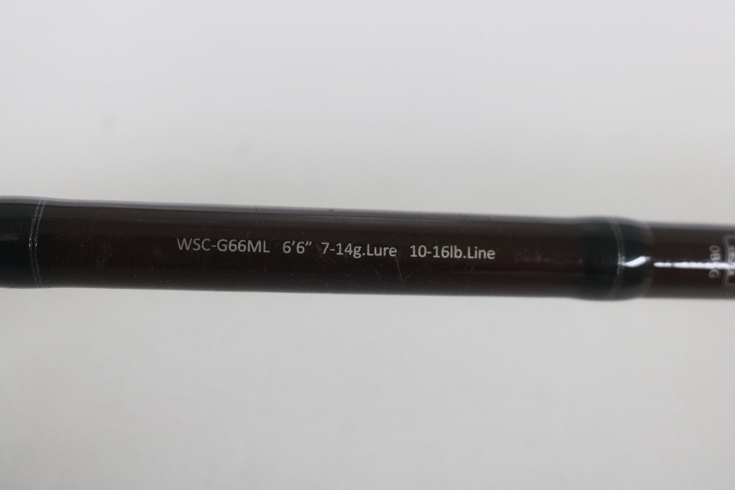 A close-up of the Legit Design Wild Side WSC-G66ML 6'6" Medium Light Used Casting Rod shows its specs in white on the dark shaft. Upgrade your rod with this Legit Design option through our Rod and Reel Trade-In Program.