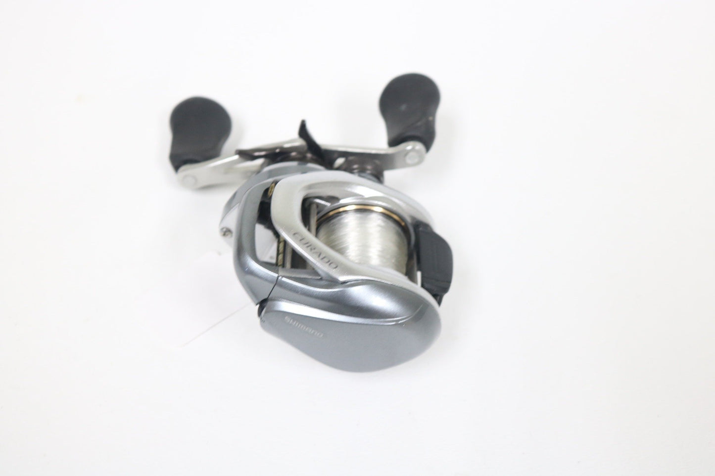 Shimano Curado I 200PG 5.5:1 Used Casting Reel in excellent condition, with black handle grips, shown on a white background. Eligible for Rod and Reel Trade-In—get store credit when you upgrade your used gear!.