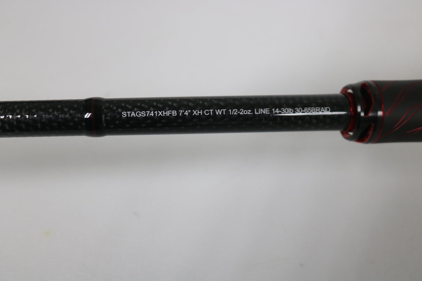 A close-up of a Daiwa Steez AGS STAGS741XHFB casting rod (used, excellent condition) shows black with red accents and white text listing: 7'4" XH CT WT 1/2-2oz. LINE 14-30lb, 30-65BRAID.