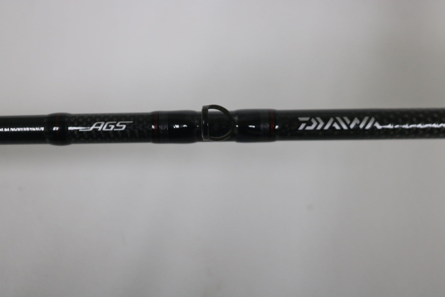 Close-up of the Daiwa Steez AGS STAGS741XHFB Used Casting Rod in excellent condition, showing "AGS" and "DAIWA" in white on carbon fiber, set against a plain light background.