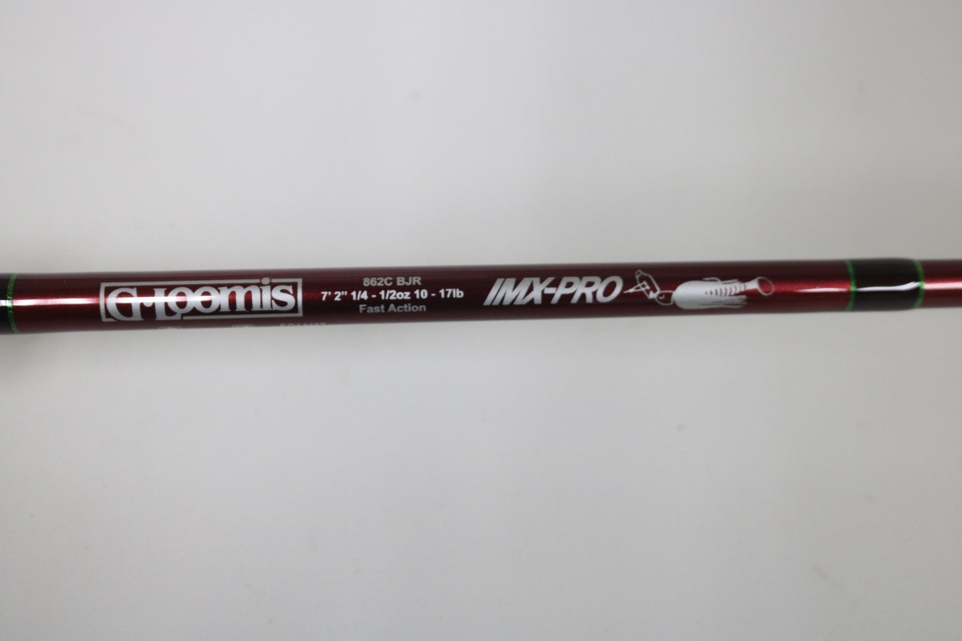 A close-up of a maroon G. Loomis IMX PRO 862C BJR 7’2” Medium Used Casting Rod in mint condition shows the label, specifications, brand logo, and a small fish graphic.