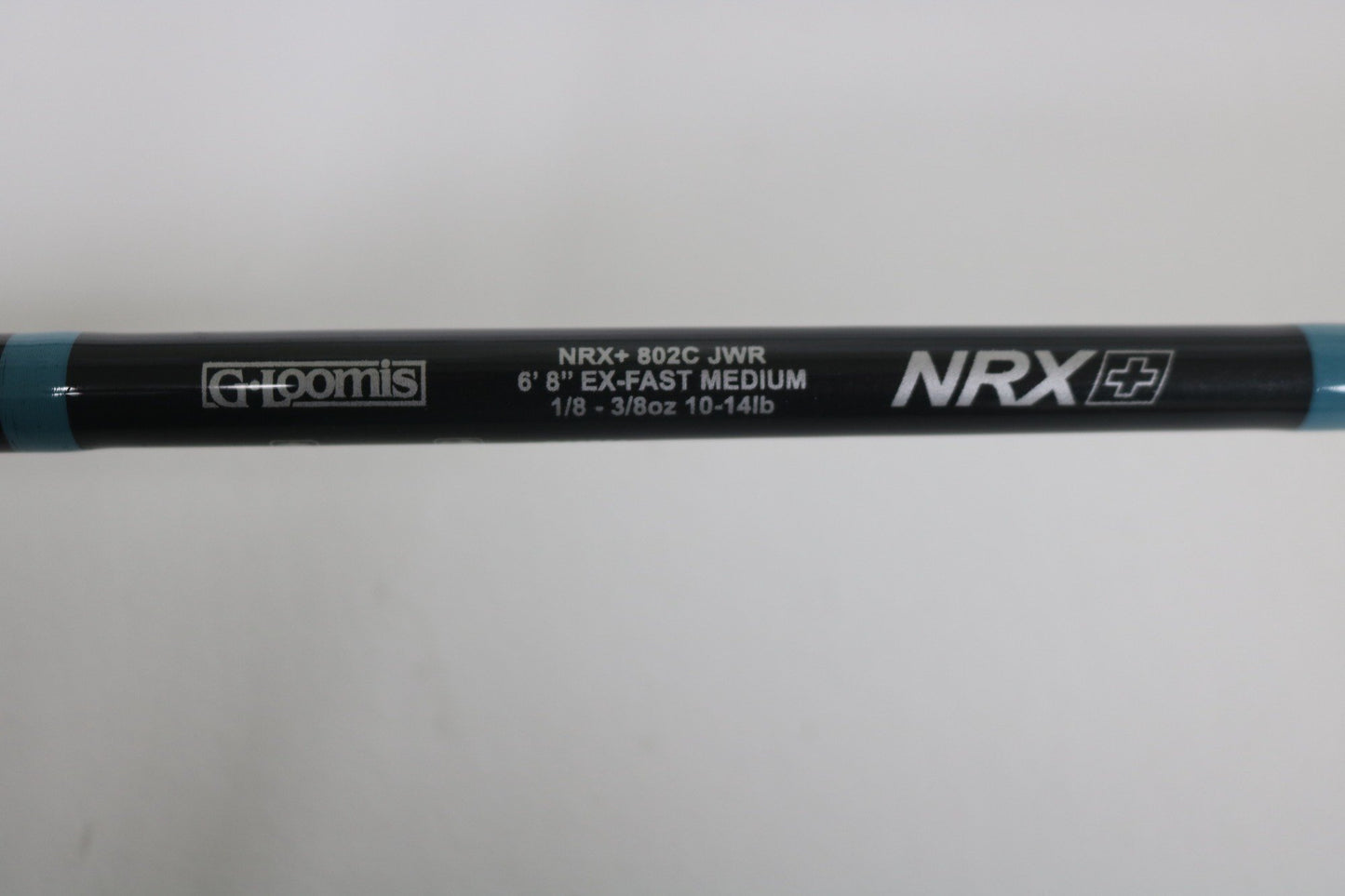 Close-up of the G. Loomis NRX+ 802C JWR Used Casting Rod in excellent condition, featuring its specs on a black background with blue accents—ideal for upgrading via our Rod and Reel Trade-In Program.