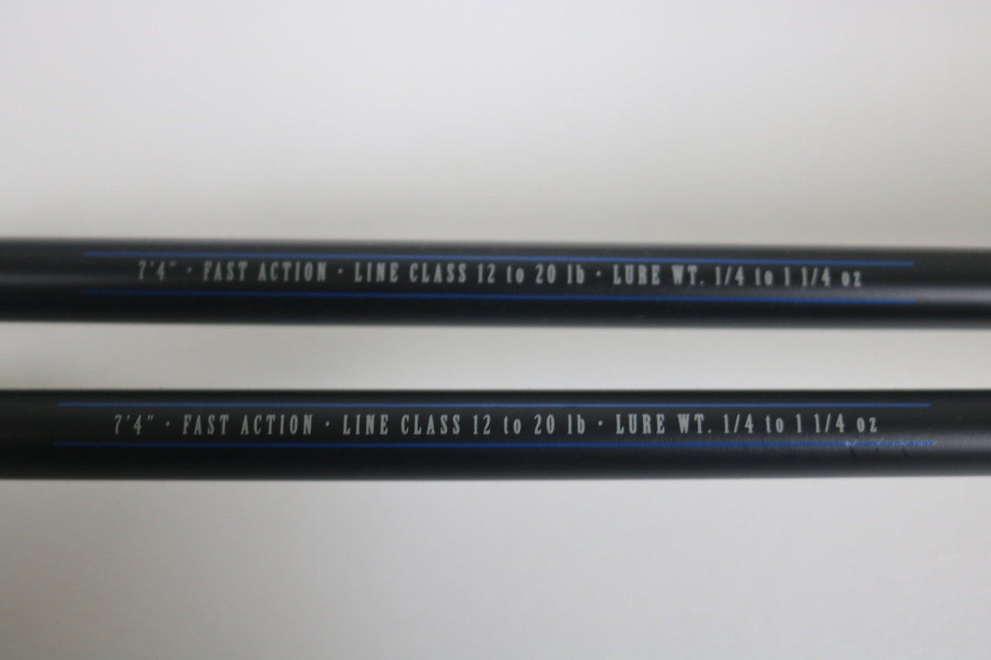 Two black Mustad BLF Instinct 7'4" Medium Heavy Casting Rods (used, very good) feature white text specs on the shafts—ideal for those trading in used gear through the Nation's Best Rod and Reel Trade-In Program.