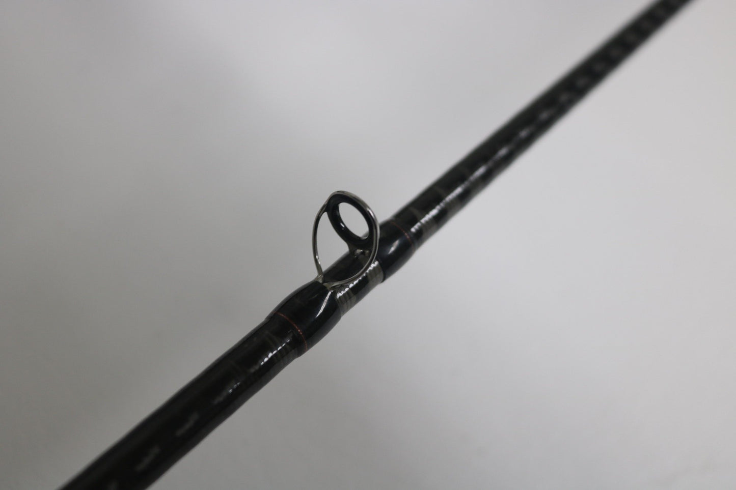 Close-up of a Shimano Zodias ZDC610MA 6'10" Medium Used Casting Rod in very good condition, highlighting one line guide against a plain background—ideal for our Rod and Reel Trade-In Program.