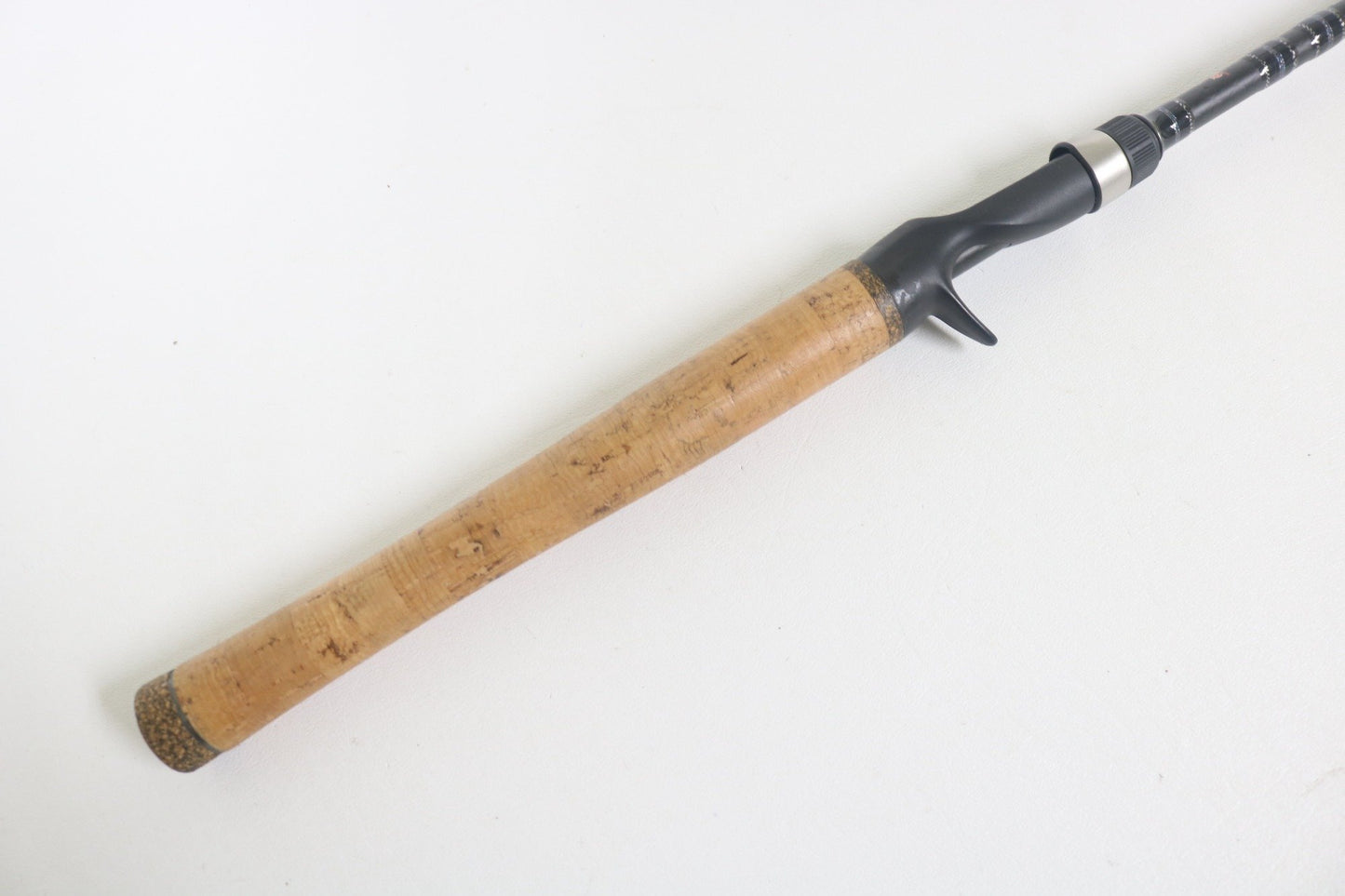 A close-up of the Dobyns Sierra SA684C Used Casting Rod by Dobyns, featuring a light brown cork grip and black reel seat, shown against a plain white background. Excellent condition.