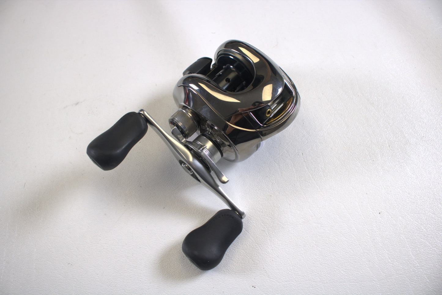 A close-up of a used Shimano Calais 200DC casting reel (7.0:1 gear ratio, black handles) in excellent condition, shown on a plain white surface.