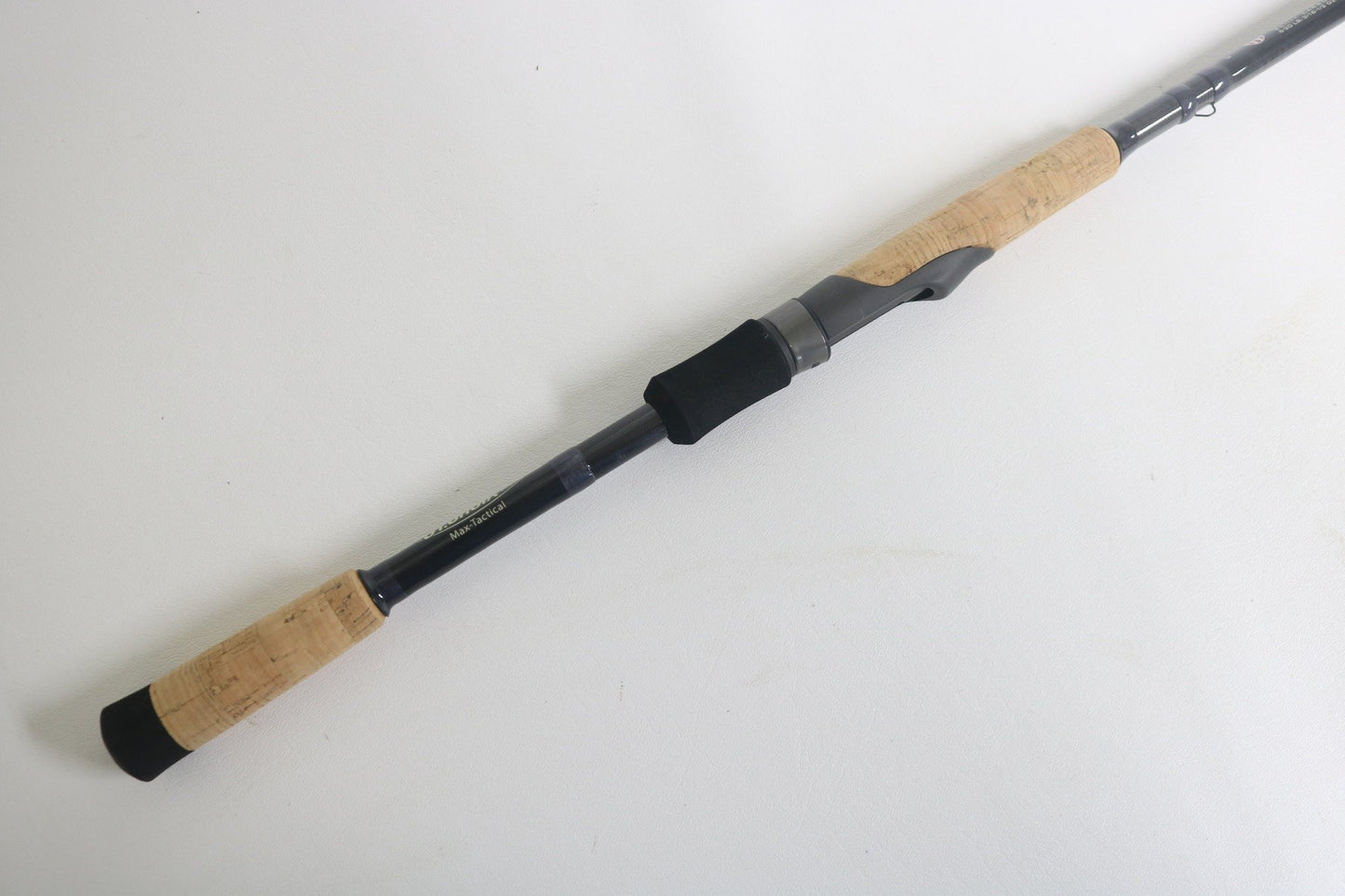 The St. Croix Victory VTS73MXF Used Spinning Rod, in excellent condition, features cork handles, a black reel seat, and a graphite body. It is shown lying diagonally on a white background.