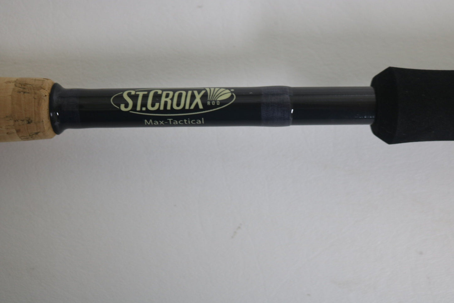 Close-up of a St. Croix Victory VTS73MXF Used Spinning Rod in excellent condition, featuring cork and black foam grips on a black handle, set against a plain white background.