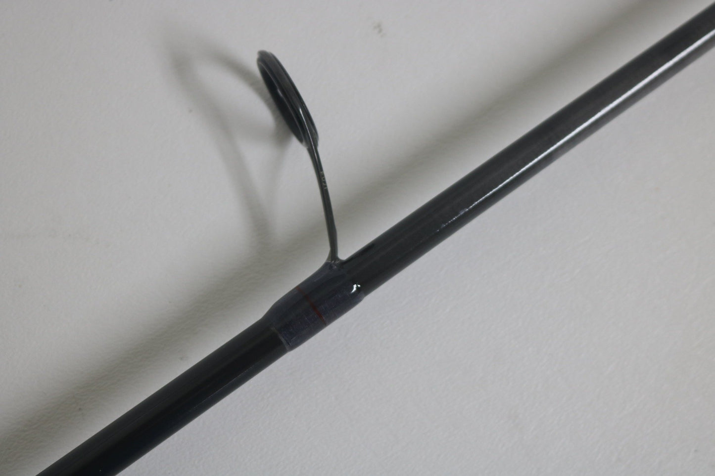 A close-up of a St. Croix Victory VTS73MXF Used Spinning Rod in excellent condition highlights one of its line guides against a plain white background.