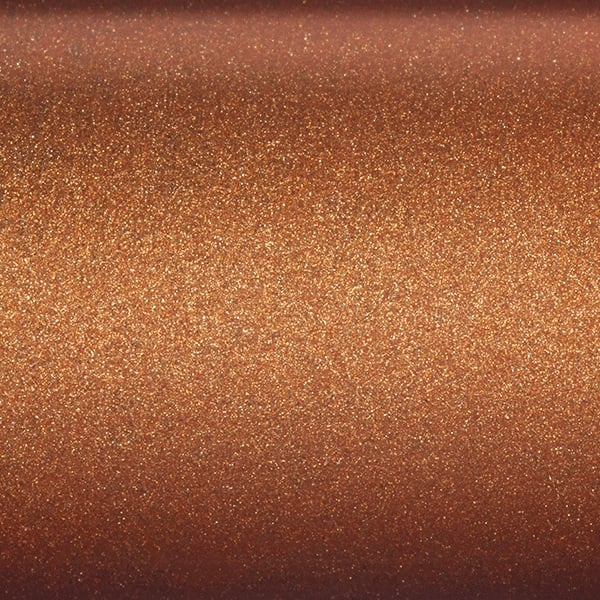 Close-up of a smooth, metallic copper surface with a shimmering, glittery texture that reflects light—reminiscent of the warm, sparkling finish on the St. Croix Legend Glass 7’2” Heavy Casting Rod (LGC72HM) by St. Croix.