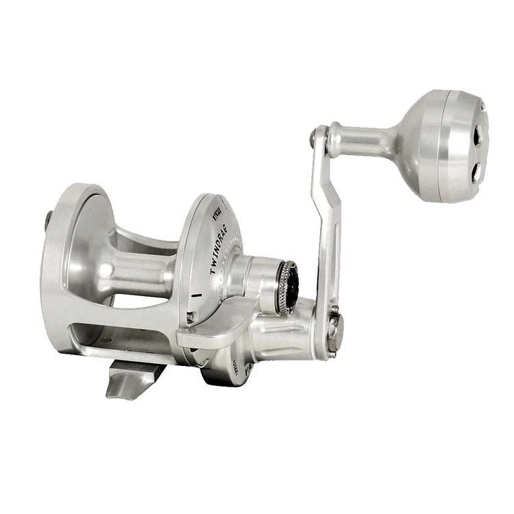 Silver fishing reel with a crank handle and exposed spool, displayed on a white background.