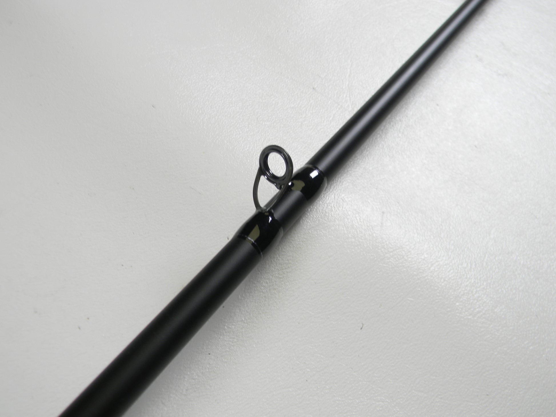 A close-up of the Dobyns Champion XP DC705C 7'0" Mag Heavy Used Casting Rod in excellent condition showcases its black finish and line guide, ideal for highlighting trade-in eligible gear for store credit.