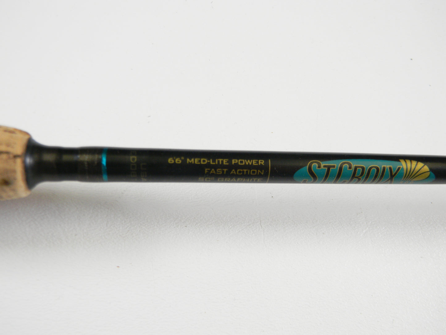 Close-up of the St. Croix Premier PS66MLF 6'6" Medium Light spinning rod (used, good condition) showing handle and label details. "St. Croix" branding in blue and gold is visible. Upgrade your gear with our Rod and Reel Trade-In Program for store credit.