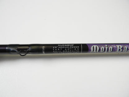 Close-up of the predominantly black St. Croix Mojo Bass Jerkbait 6'8" medium power casting rod, with purple accents and SCIII graphite featuring IPC technology, ideal for our trade-in program or earning store credit.