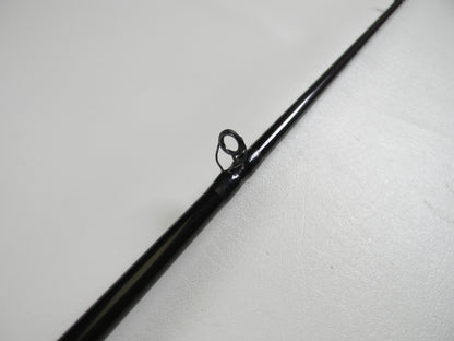 Close-up of a St. Croix Mojo Bass MJC68MF Jerkbait 6'8" Medium casting rod tip in black, featuring a single guide ring on a light surface, ideal for those seeking an upgrade through our trade-in program to earn store credit.