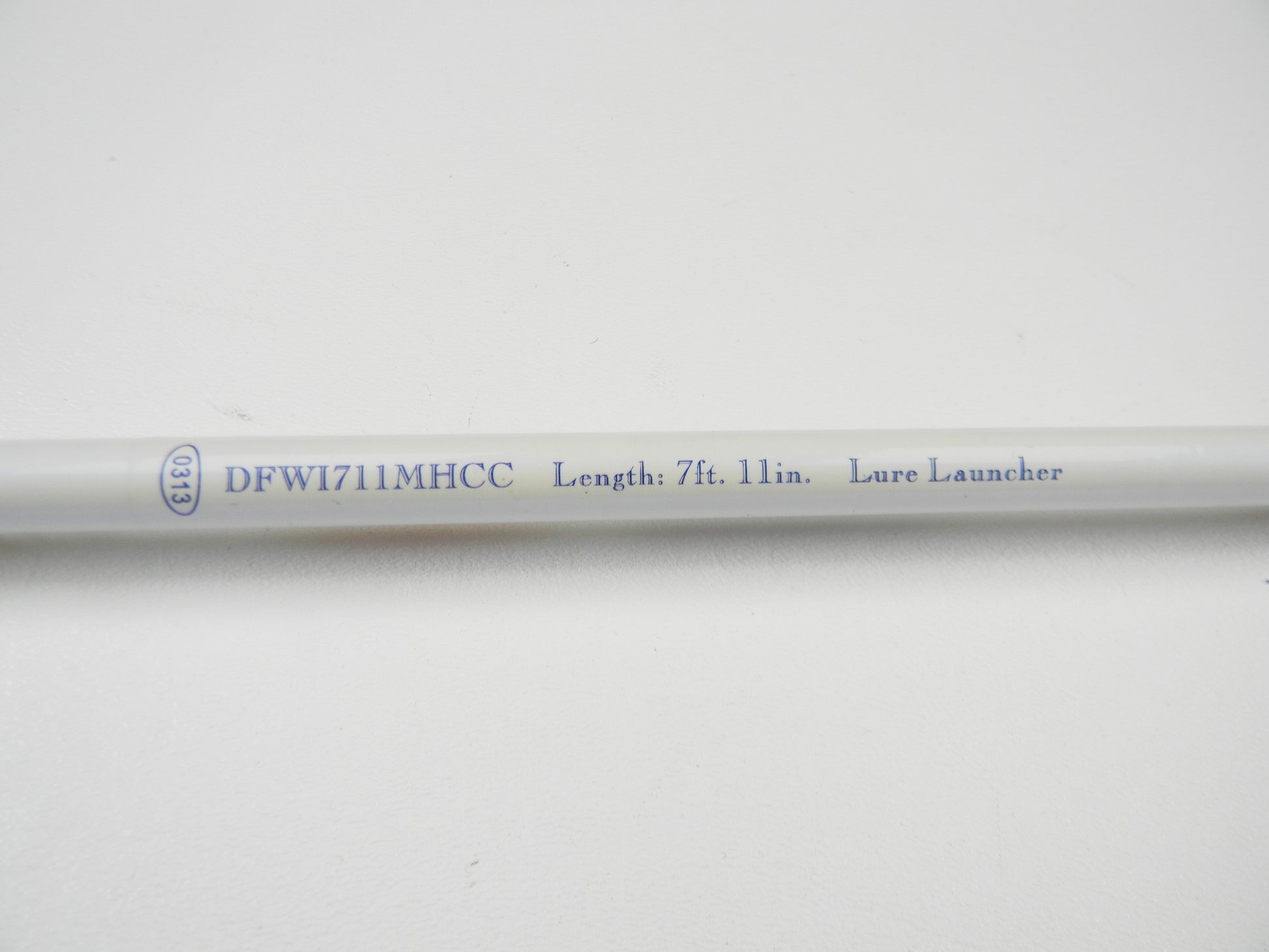 Close-up of a Duckett White Ice DFWI711MHCC Byron Velvick 7'11" Medium Heavy Lure Launcher, showing "DFW1711MHCC Length: 7 ft. 11 in." The used casting rod is in very good condition and features black text on a white background, ideal for Rod and Reel Trade-In opportunities.