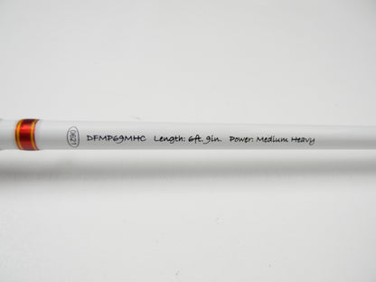 Close-up of Duckett Micro Magic Pro DFMP69MHC, 6'9", Medium Heavy. The rod has a white surface with red accents and is ideal for the Rod and Reel Trade-In Program's quality used gear seekers.