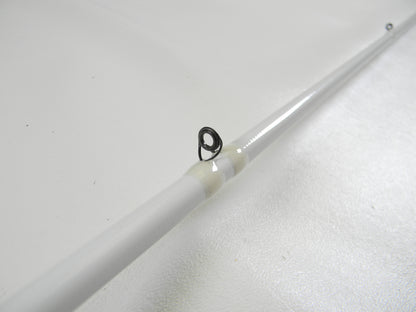 Close-up of a white Duckett Micro Magic Pro DFMP69MHC 6'9" Medium Heavy casting rod with a metal guide loop against a white background, highlighting its sleek design. Ideal for those participating in our Rod and Reel Trade-In Program to earn store credit or upgrade used gear.