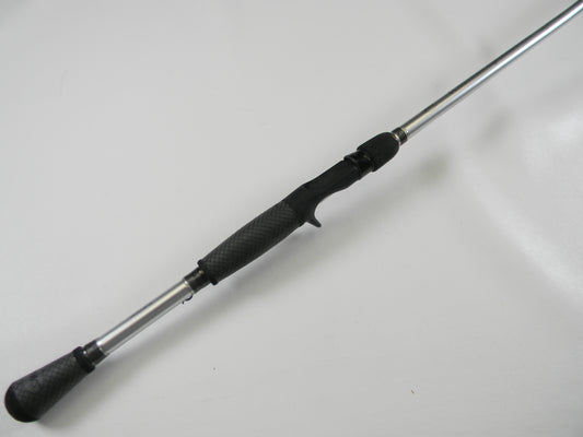 The Lew's Signature Series TLS76H Pitching 7'6" Heavy casting rod, with its black textured grip and sleek silver shaft, lies on a white surface, ready for your next adventure. Use our Rod and Reel Trade-In Program to exchange used gear for store credit and enhance your fishing experience.