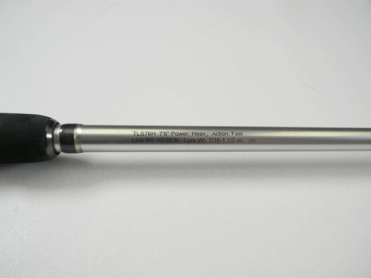 Close-up of the Lew's Signature Series TLS76H Pitching 7'6" Heavy Casting Rod, engraved with details and featuring a black foam grip and silver shaft. This used rod is in excellent condition and eligible for our Rod and Reel Trade-In Program for store credit.