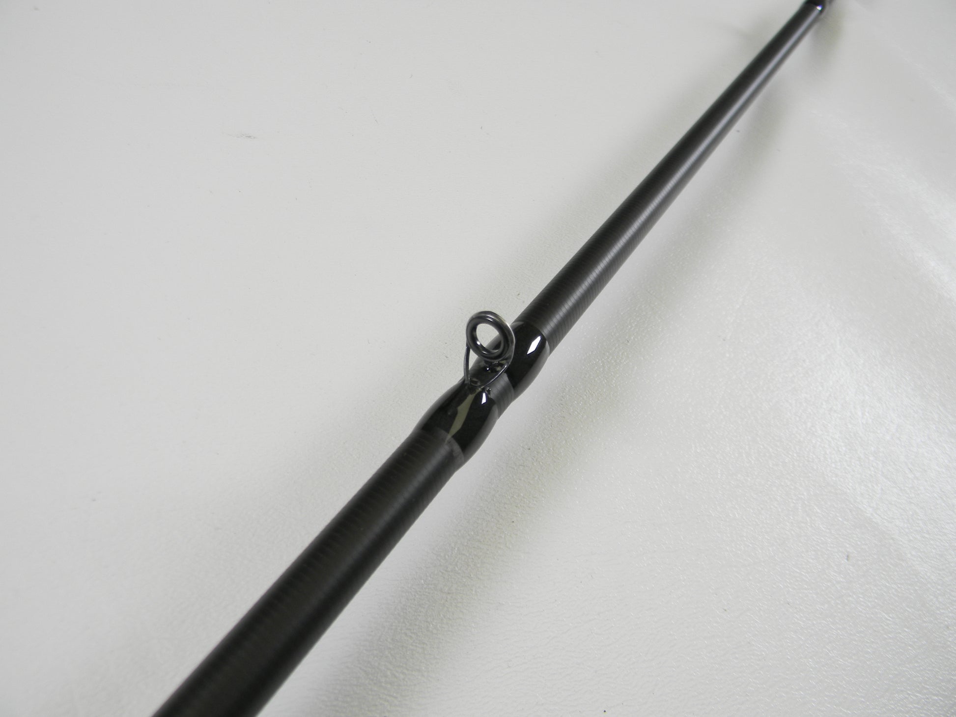 Close-up view of the Kistler KLX KLX-TCJ-70MH 7'0" Medium Heavy used casting rod guide against a white background, showcasing its sleek design. Ideal for our rod and reel trade-in program.
