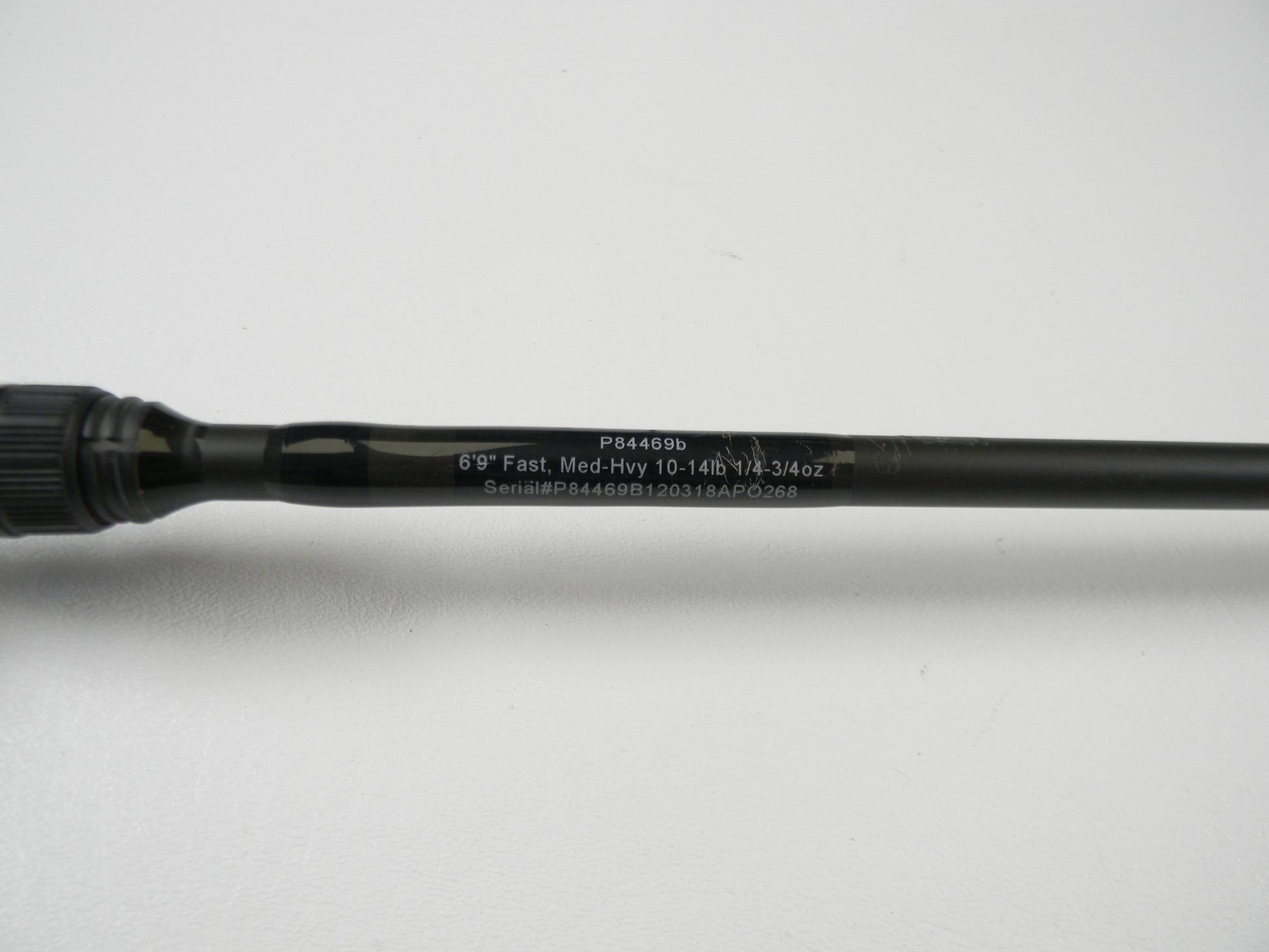 The Cashion P84469b 6'9" Medium Heavy used casting rod, in good condition, features details like "Fast, 10-14lb, 1/2-3/4oz" and the serial number "P84469B120318APO268." It's ideal for a rod and reel trade-in to earn store credit. The sleek black shaft is displayed on a white surface.