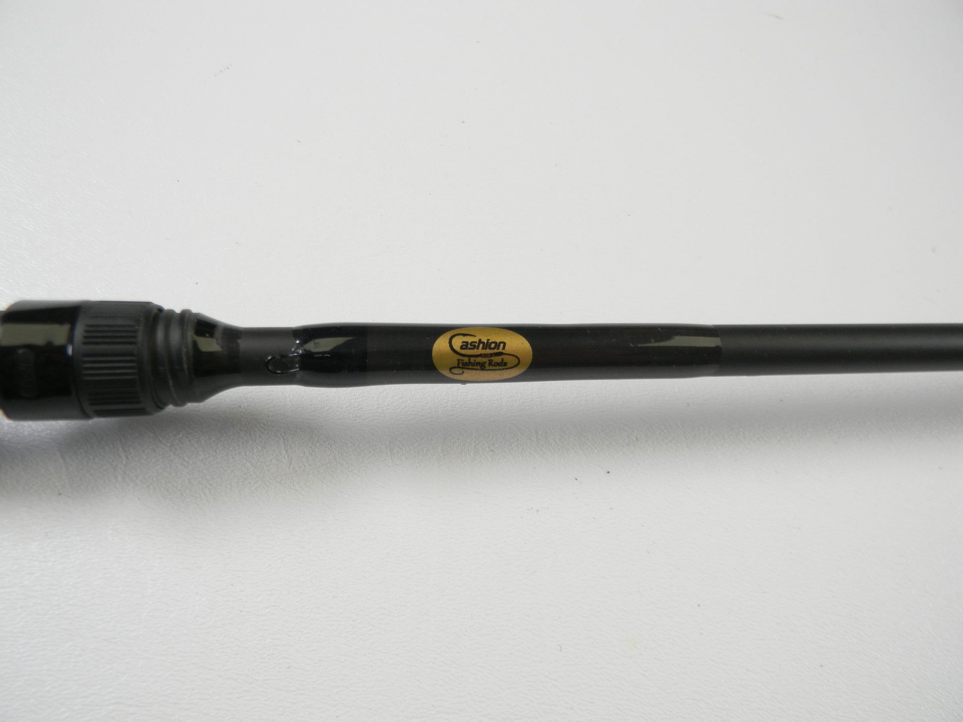 Close-up of a black fishing rod with a glossy finish, labeled "Cashion" in gold and black. Ideal for trading in used gear at select stores for credit. The sleek Cashion P84469b 6'9" Medium Heavy casting rod is displayed elegantly on a white background, showcasing its good condition.