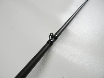Close-up of a Cashion P84469b 6'9" medium heavy used casting rod in good condition with a shiny metallic eyelet, resting on a smooth white surface. This product may qualify for our rod and reel trade-in program, offering potential store credit.