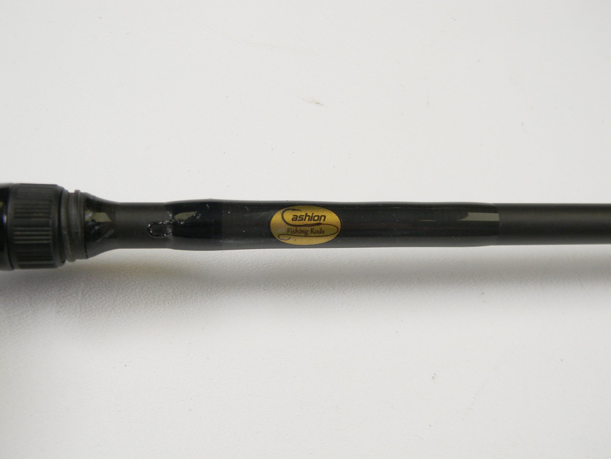 Close-up of a black fishing rod labeled "Cashion" on a white background, featuring the Cashion F90474b 7'4" Medium Heavy - Used Casting Rod in very good condition, ideal for upgrades through our Rod and Reel Trade-In program.
